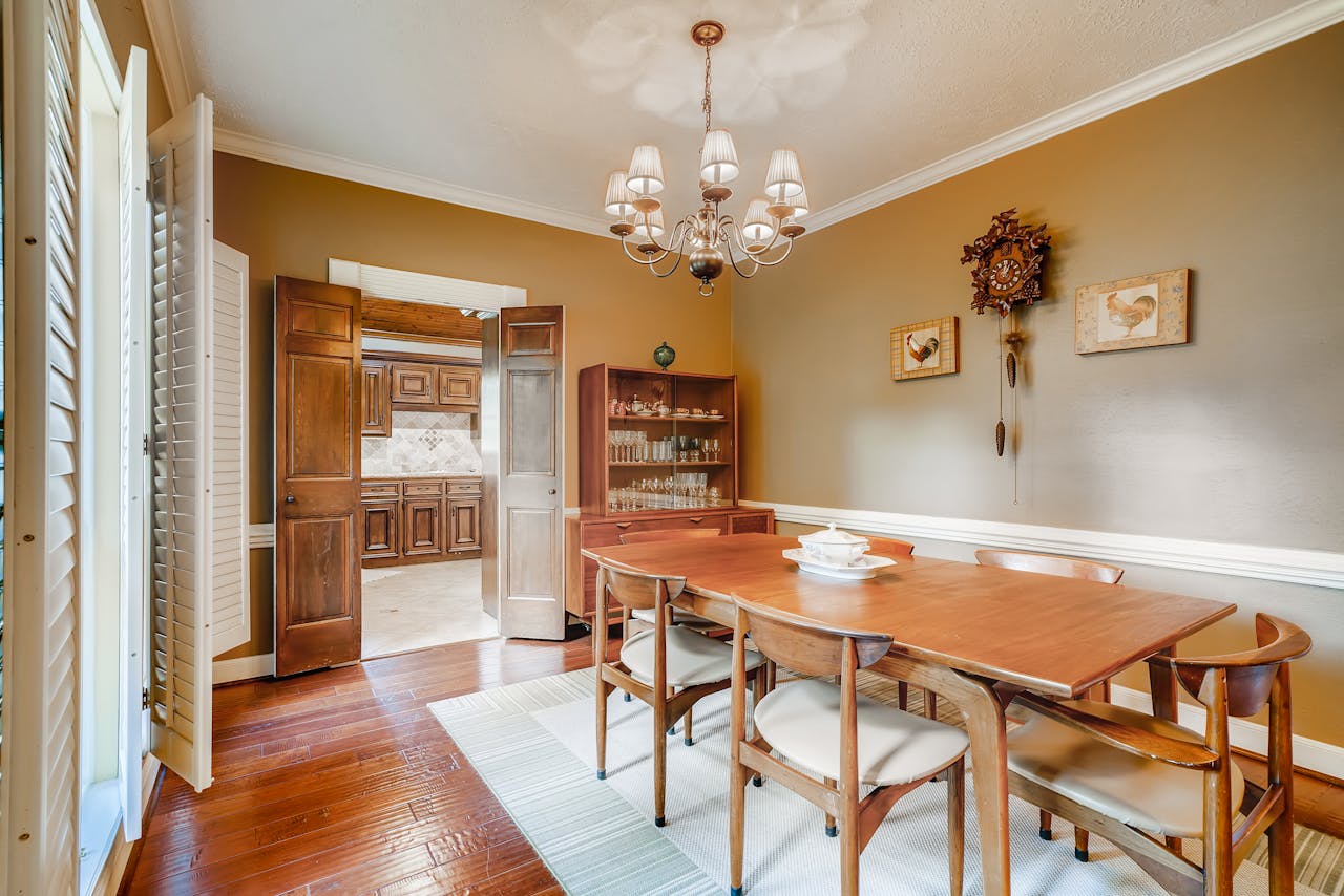 Cozy dining room with wooden furniture and chandelier, ideal for homes.